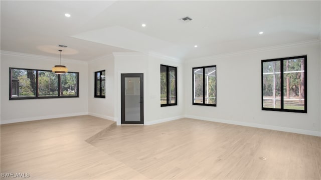 spare room with light hardwood / wood-style floors, ornamental molding, and a wealth of natural light