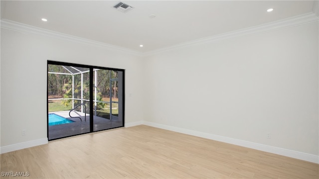 empty room featuring light hardwood / wood-style floors and crown molding