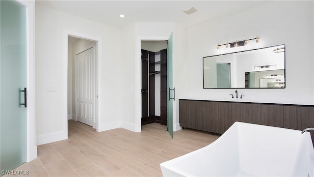 bathroom featuring vanity, a bathtub, and hardwood / wood-style floors