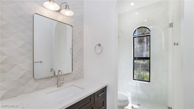 bathroom with toilet, a shower with shower door, and vanity