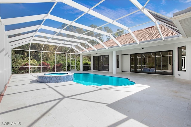 view of pool featuring an in ground hot tub, ceiling fan, glass enclosure, and a patio area