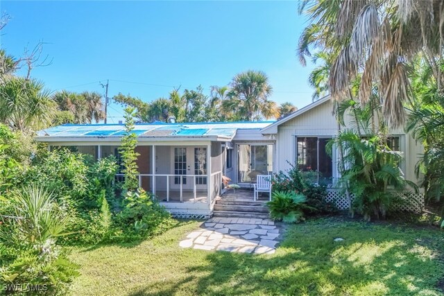 back of property featuring a yard and french doors