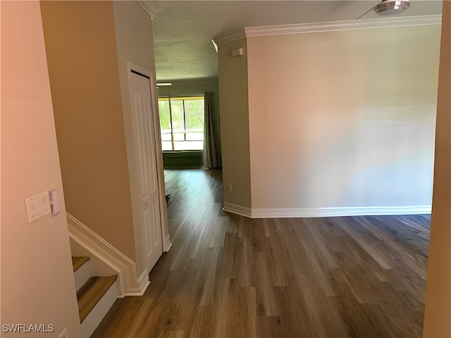 hallway with dark wood-type flooring and crown molding