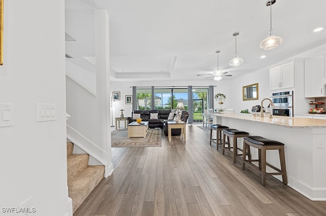 living room featuring light wood-type flooring and ceiling fan