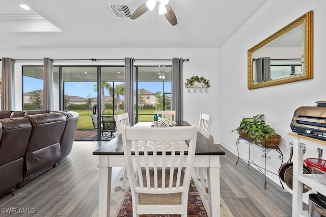 dining space with ceiling fan, wood-type flooring, and ornamental molding