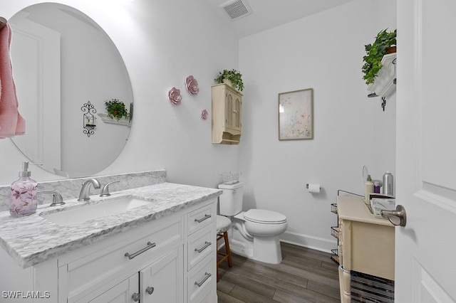 bathroom with vanity, wood-type flooring, and toilet