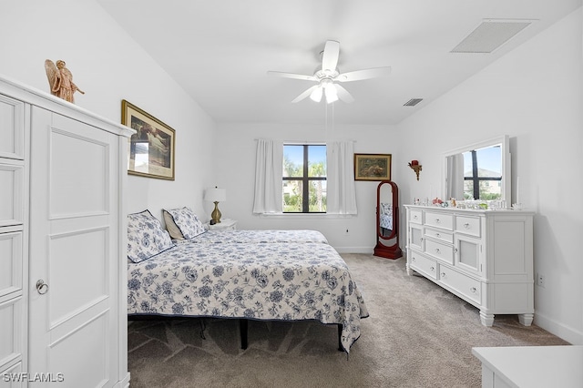 bedroom with light carpet, multiple windows, and ceiling fan