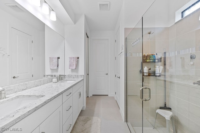 bathroom featuring vanity, a shower with shower door, and tile patterned flooring