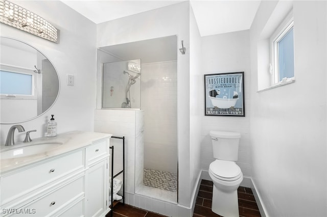 bathroom featuring vanity, toilet, tiled shower, and hardwood / wood-style floors