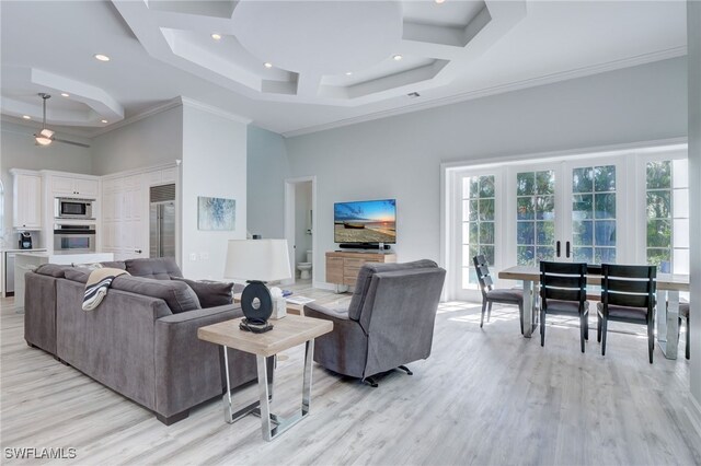 living room featuring french doors, a towering ceiling, light hardwood / wood-style floors, and ornamental molding