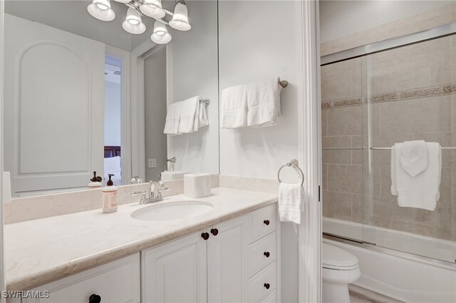 full bathroom featuring vanity, toilet, and enclosed tub / shower combo