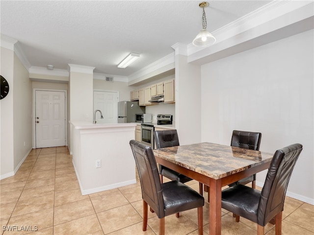 tiled dining area featuring sink, ornamental molding, and a textured ceiling