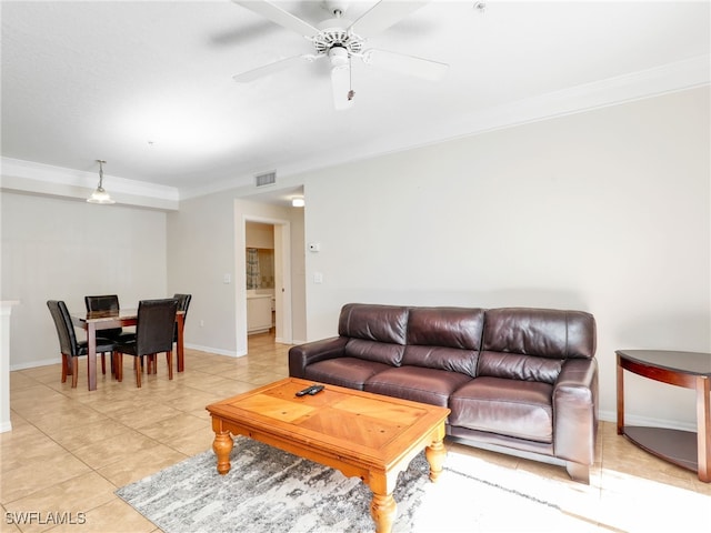 living room with ceiling fan, ornamental molding, and light tile patterned flooring