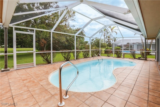 view of swimming pool featuring a patio, a lawn, and glass enclosure