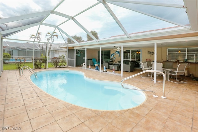 view of pool with a patio area, glass enclosure, and ceiling fan