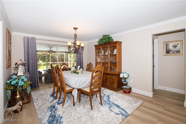 dining room with an inviting chandelier, light hardwood / wood-style flooring, and crown molding