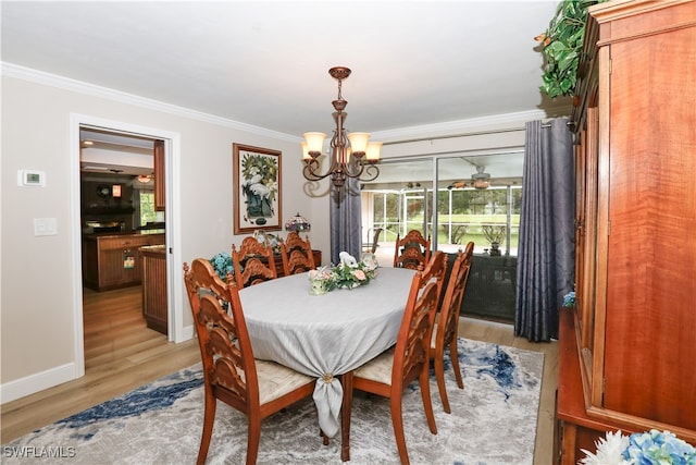 dining area with ornamental molding, light hardwood / wood-style flooring, and a notable chandelier