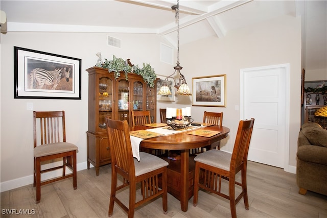 dining area featuring lofted ceiling with beams and light wood-type flooring