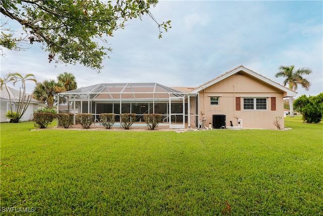 rear view of property with a yard, cooling unit, and a lanai