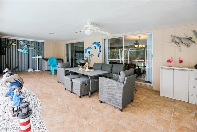 living room featuring ceiling fan with notable chandelier and light tile patterned floors