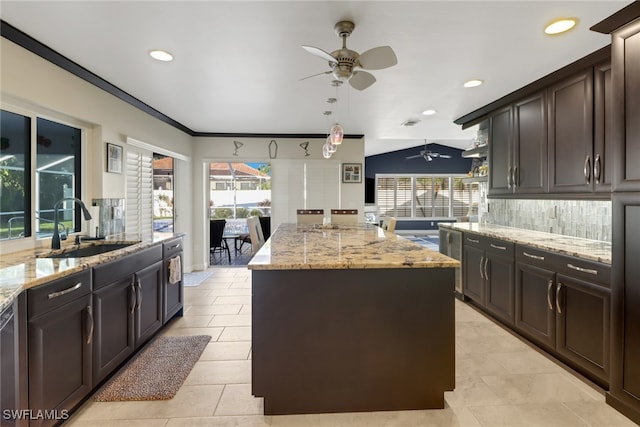 kitchen featuring light stone countertops, sink, a center island, and plenty of natural light