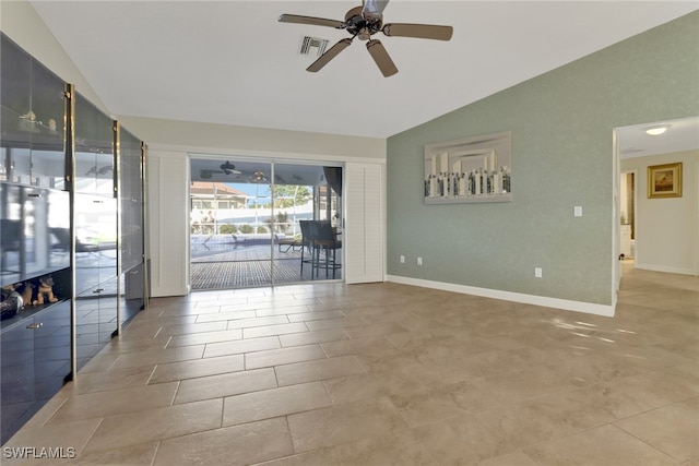 tiled empty room featuring vaulted ceiling and ceiling fan