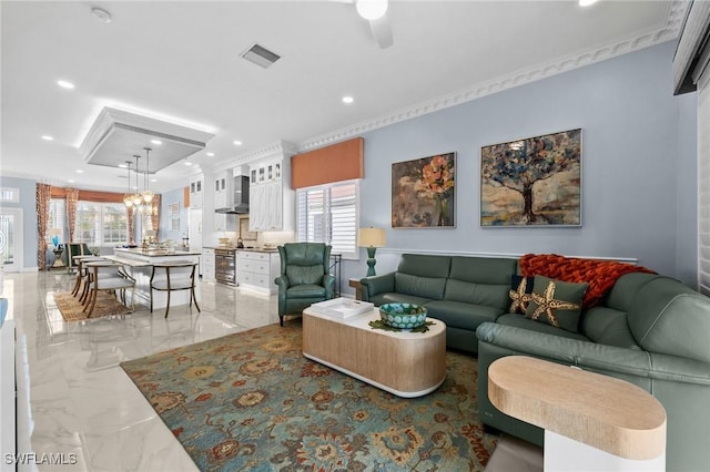 living room with ceiling fan and crown molding