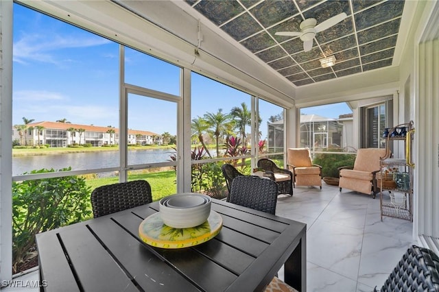 sunroom / solarium with a wealth of natural light, a water view, and ceiling fan