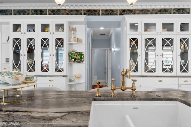 interior space featuring crown molding, white cabinetry, and sink