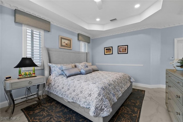 bedroom featuring a raised ceiling and ceiling fan