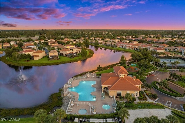 aerial view at dusk featuring a water view