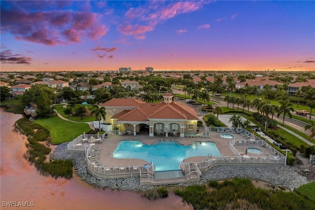 pool at dusk with a patio area