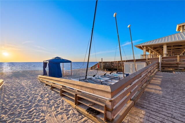 dock area with a water view and a view of the beach