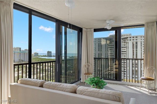 sunroom featuring a water view and a view of city