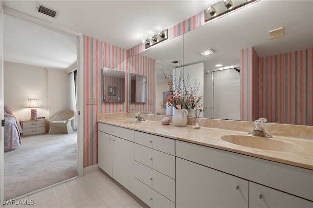 bathroom with a sink, ensuite bath, visible vents, double vanity, and wallpapered walls