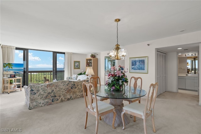 dining area featuring a water view, light carpet, and an inviting chandelier