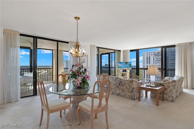 carpeted dining area with an inviting chandelier and a wall of windows