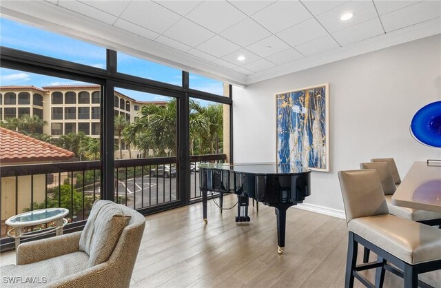 living area featuring baseboards, crown molding, recessed lighting, and wood finished floors
