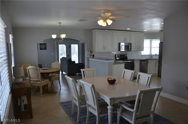 dining room featuring sink, ceiling fan with notable chandelier, and light tile patterned floors