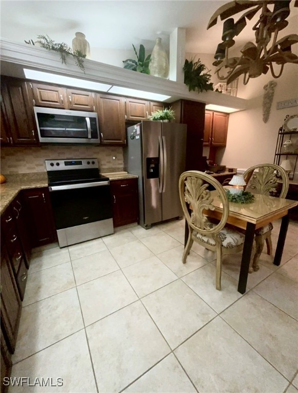 kitchen with stainless steel appliances, backsplash, and light tile patterned floors