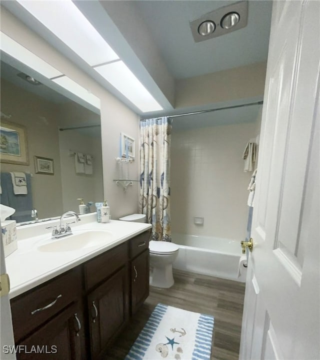 full bathroom with vanity, hardwood / wood-style floors, shower / bath combo, and toilet