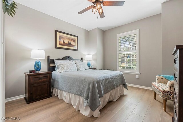 bedroom with light hardwood / wood-style floors and ceiling fan