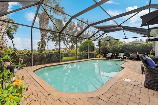 view of pool with a patio area and glass enclosure