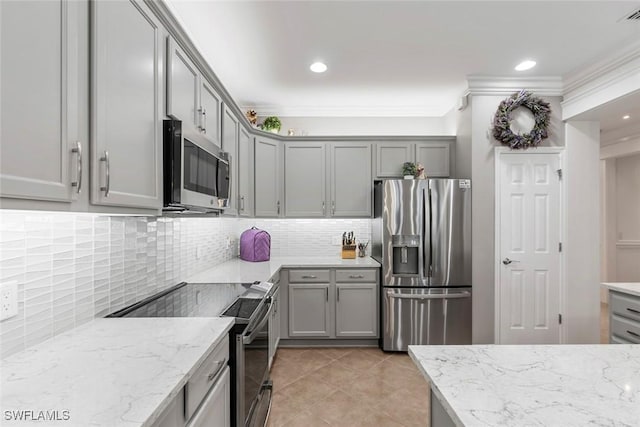 kitchen with crown molding, stainless steel appliances, and light stone counters