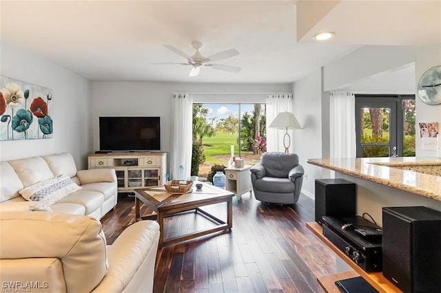 living room featuring dark hardwood / wood-style floors, ceiling fan, and a wealth of natural light