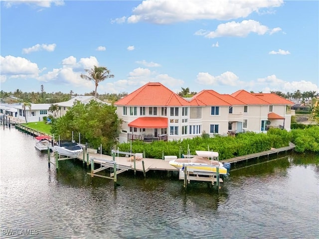 back of house with a tile roof, a water view, and boat lift