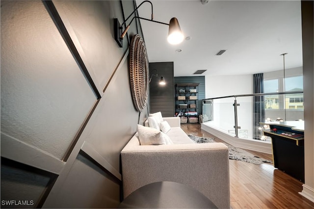 living area with visible vents and wood finished floors