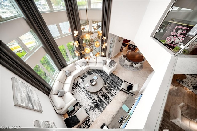 living area with a chandelier and a towering ceiling