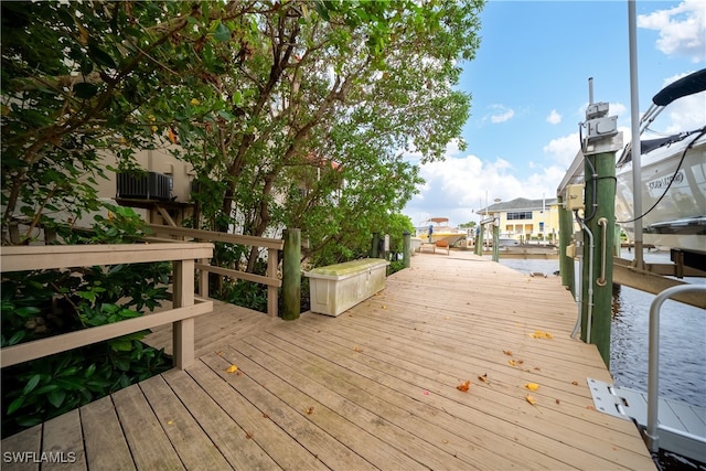 wooden deck with a water view and a boat dock