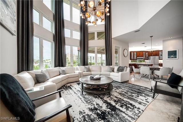 living room with a chandelier, visible vents, and a towering ceiling